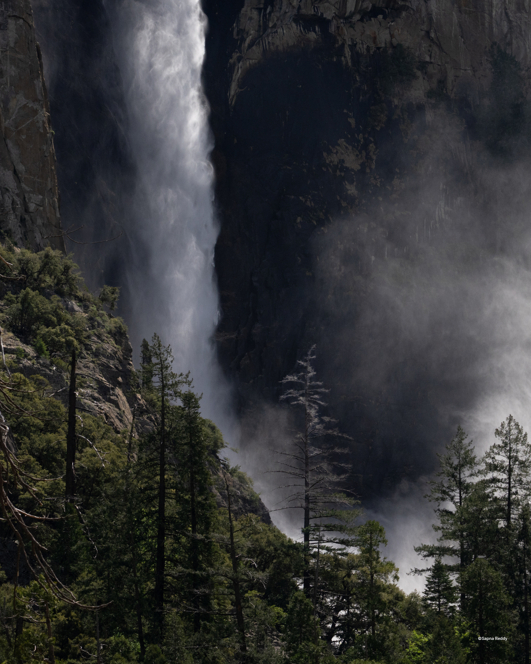 A wide Yosemite vista with a waterfall and dramatic sky